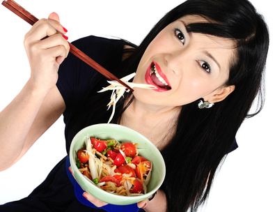 Young asian girl eating salad